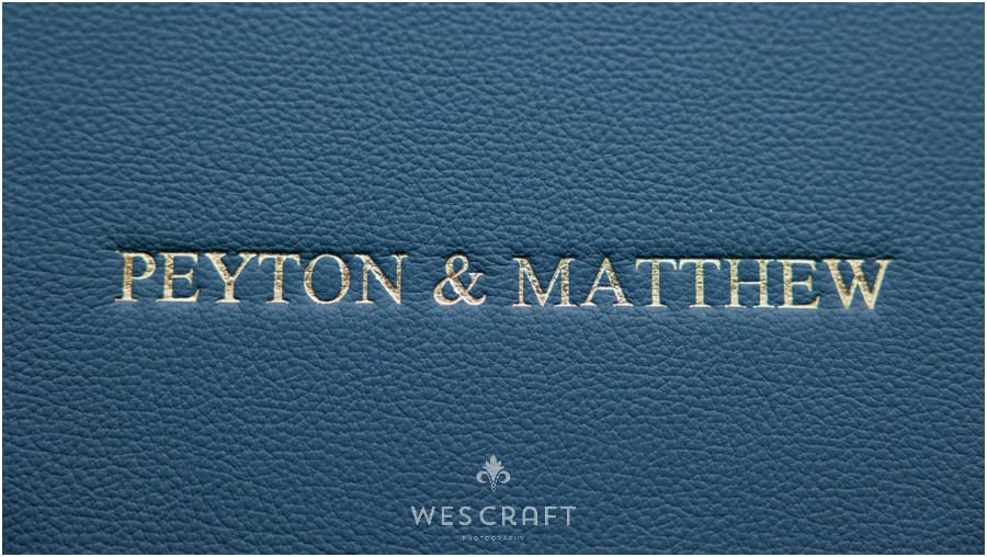 Close Up Feature of Gold Foil Embossing on Navy Leather. The Title is in All Caps Times New Roman Font.